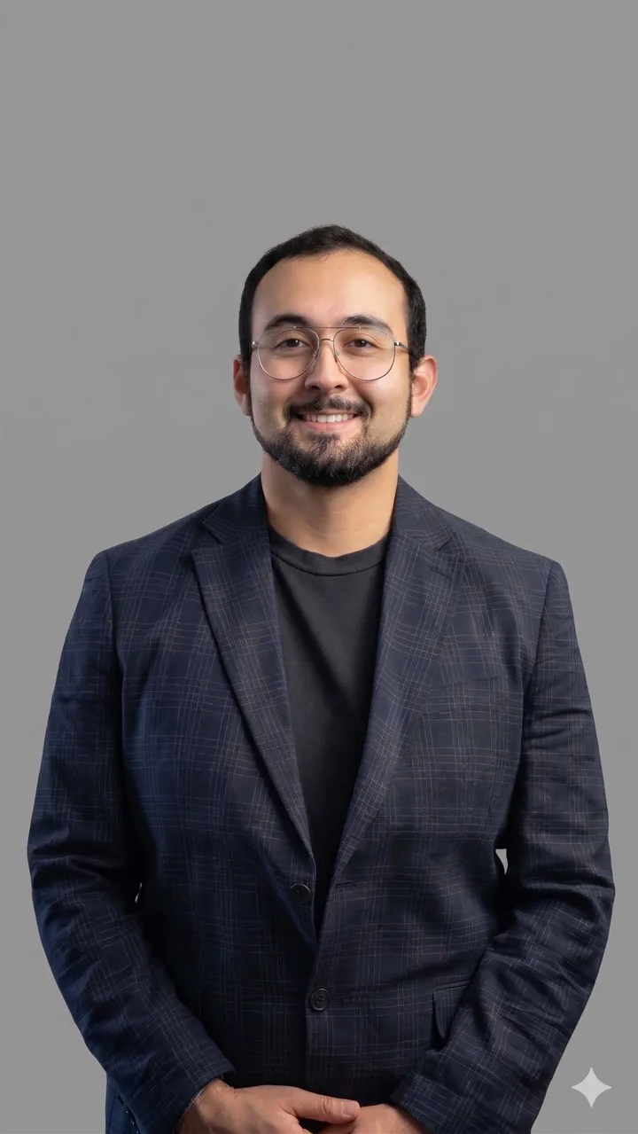 Retrato profesional de estudio de Benjamín Brante sonriendo, con blazer azul marino y lentes, proyectando cercanía y confianza para su portafolio profesional.
